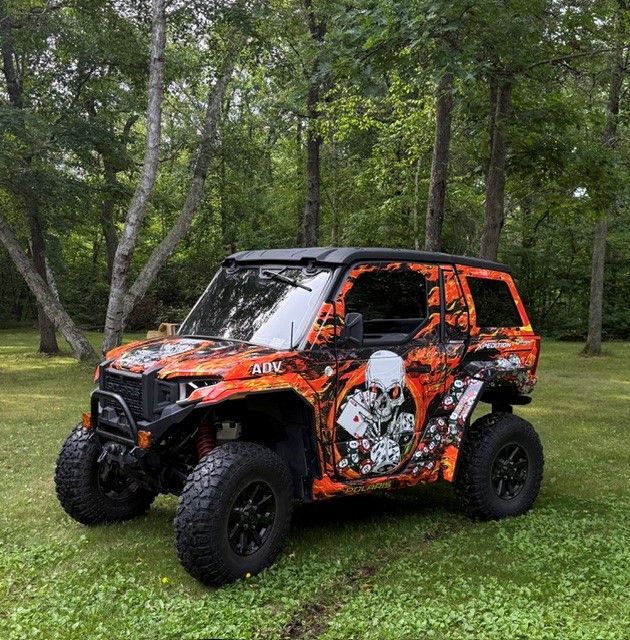 A Polaris Xpedition 2 door side-by-side with a custom design vinyl wrap and silver flake laminate